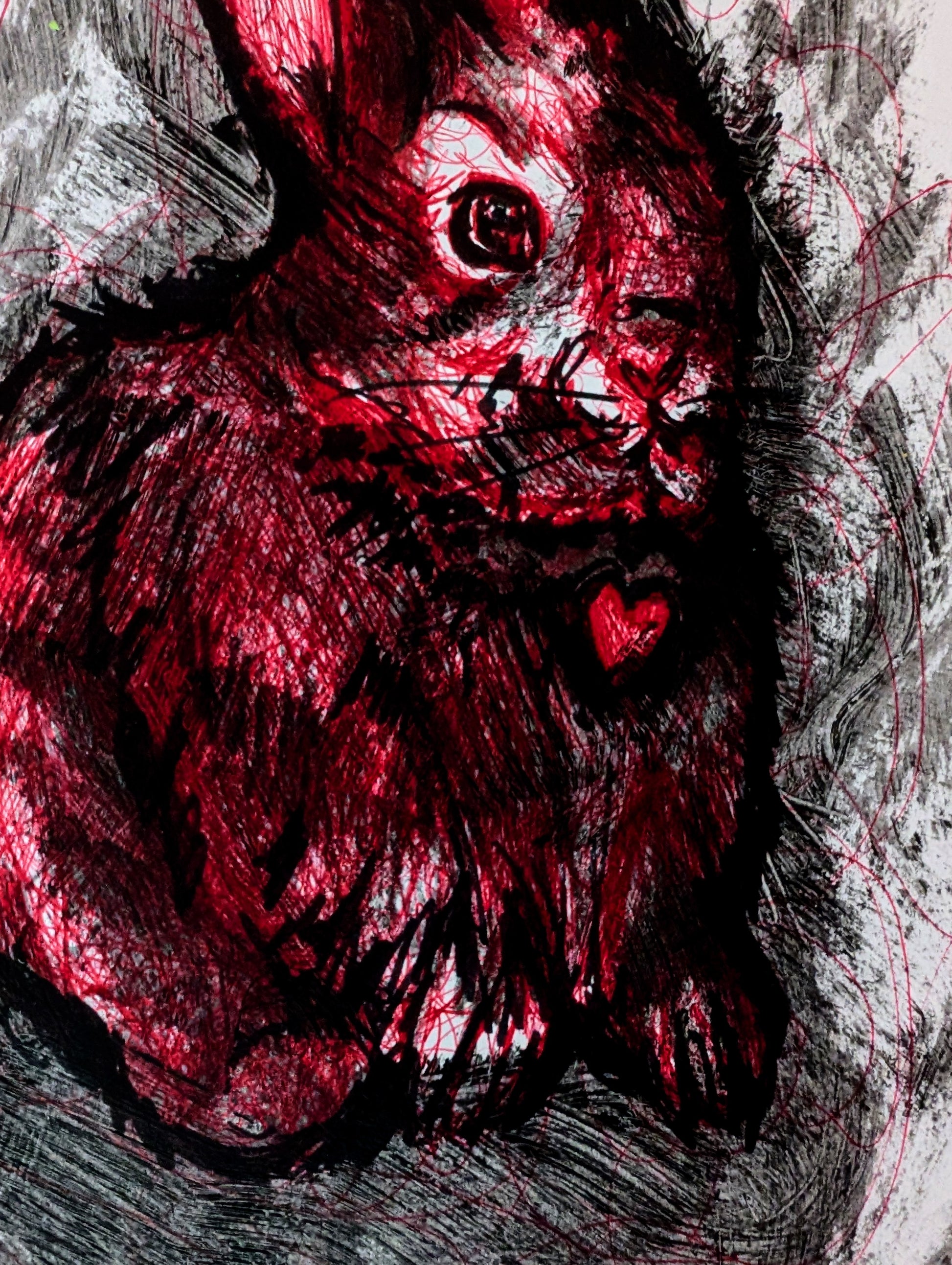 Red rabbit with a heart on its chest against a black and white background